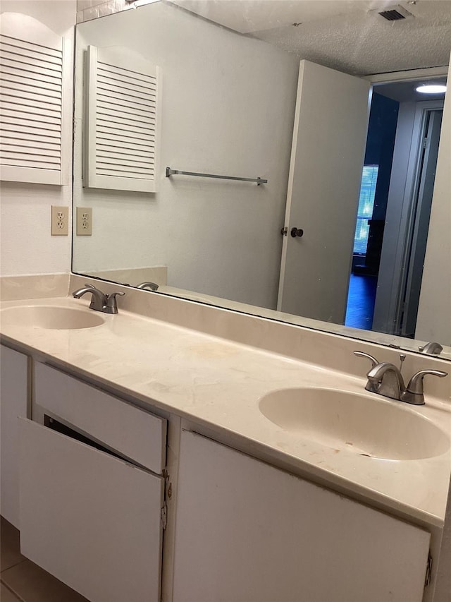 bathroom featuring vanity, tile patterned flooring, and a textured ceiling