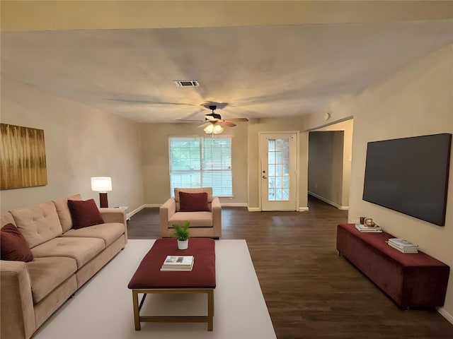 living area with dark wood finished floors, a ceiling fan, visible vents, and baseboards