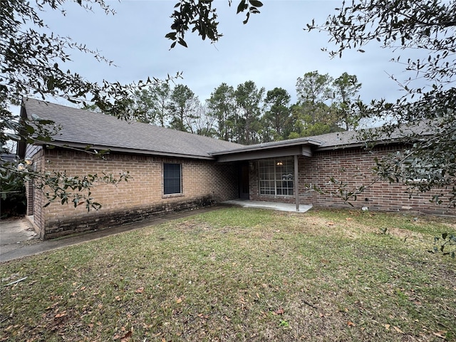 back of property with a yard and a patio