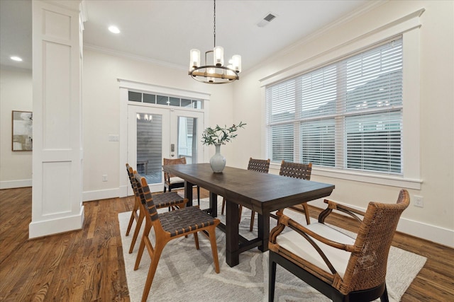 dining space featuring an inviting chandelier, dark wood-type flooring, ornamental molding, and french doors