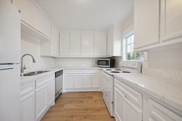 kitchen with sink, stainless steel appliances, white cabinets, and light stone countertops