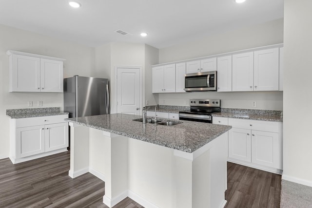 kitchen featuring dark wood-type flooring, sink, stainless steel appliances, a kitchen island with sink, and white cabinets