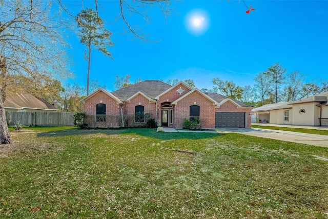 view of front of property featuring brick siding, fence, concrete driveway, and a front yard