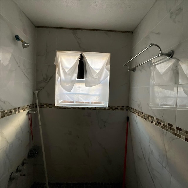 bathroom with a textured ceiling and a shower