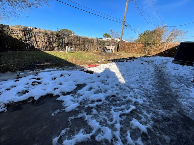 yard covered in snow featuring central AC unit