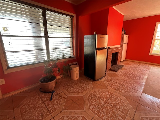 kitchen with light tile patterned flooring, white fridge, stainless steel refrigerator, and a brick fireplace