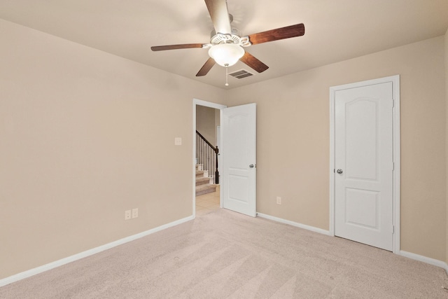 unfurnished bedroom featuring ceiling fan and light carpet