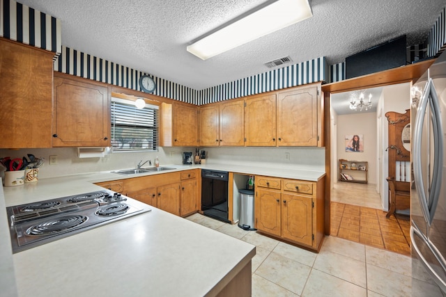 kitchen featuring appliances with stainless steel finishes, sink, light tile patterned floors, and a textured ceiling