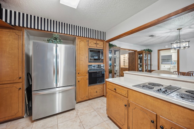 kitchen with light tile patterned flooring, decorative light fixtures, black appliances, a textured ceiling, and an inviting chandelier