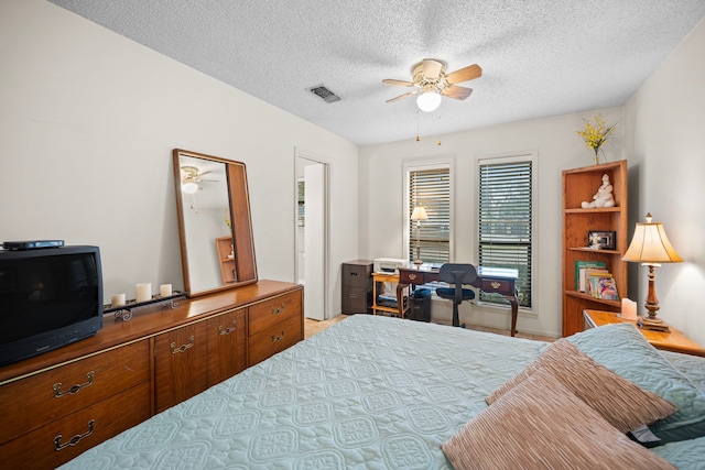 bedroom with a textured ceiling and ceiling fan