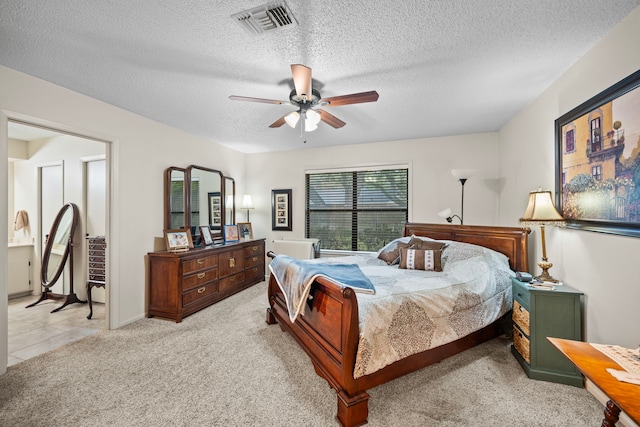 carpeted bedroom featuring a textured ceiling and ceiling fan