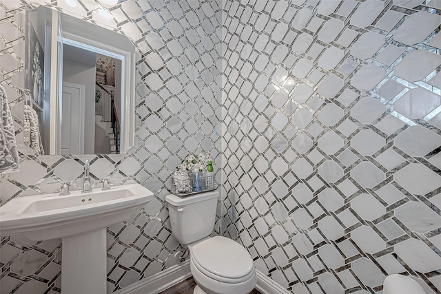 bathroom featuring tile walls, backsplash, and toilet