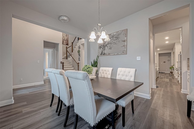 dining space with wood-type flooring and a notable chandelier