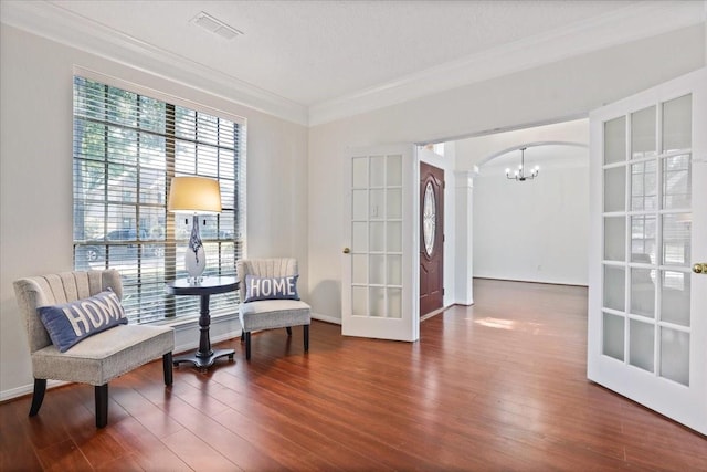 sitting room with french doors, crown molding, dark hardwood / wood-style floors, and ornate columns