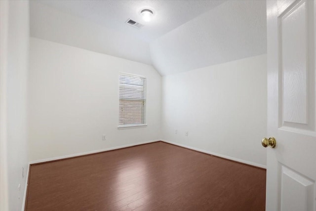 additional living space with lofted ceiling and dark hardwood / wood-style flooring