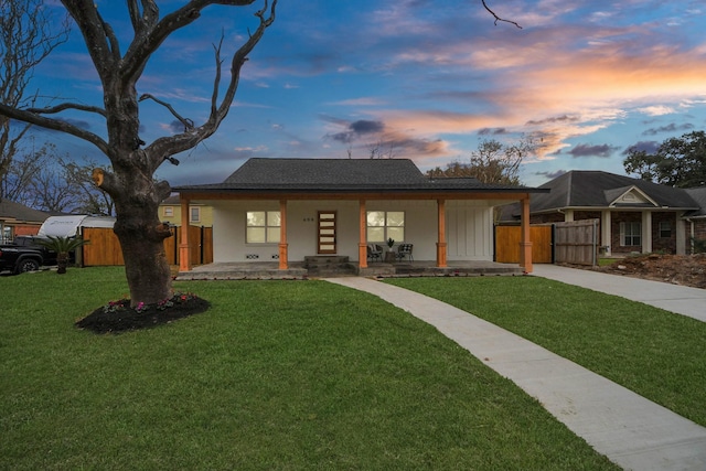 ranch-style home featuring a yard and covered porch