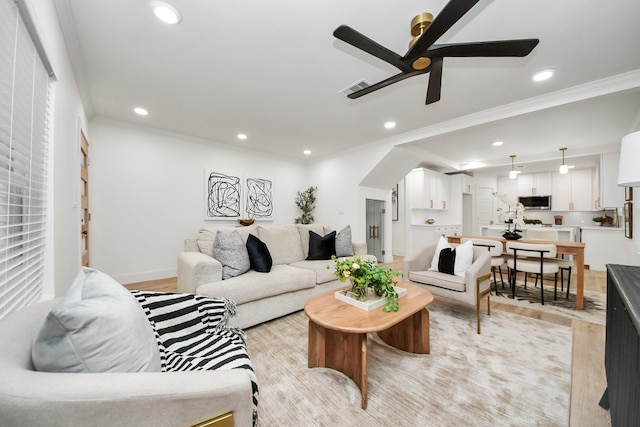 living room with crown molding, ceiling fan, and light hardwood / wood-style floors