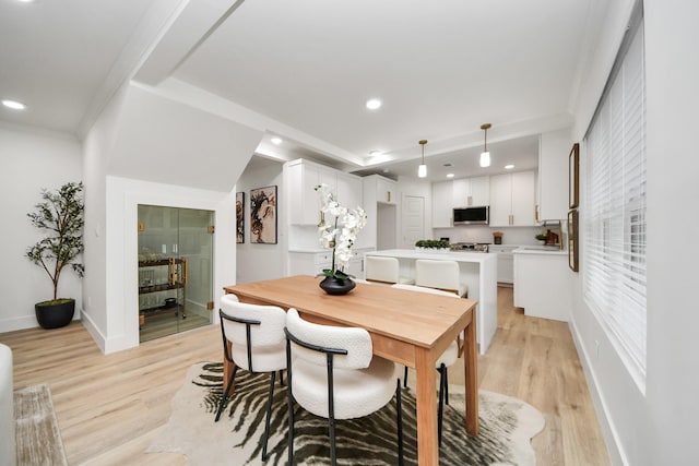 dining area with plenty of natural light, ornamental molding, and light wood-type flooring