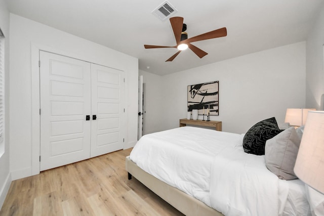 bedroom with light hardwood / wood-style flooring, a closet, and ceiling fan