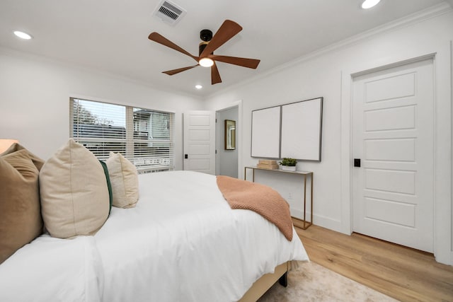 bedroom featuring light hardwood / wood-style flooring, ornamental molding, and ceiling fan