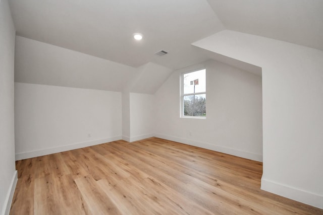 bonus room featuring lofted ceiling and light hardwood / wood-style flooring