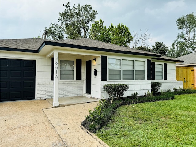 single story home featuring a garage and a front lawn