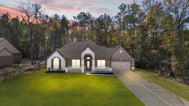 view of front of house with a garage and a lawn