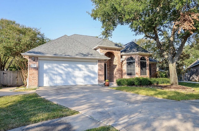 ranch-style home featuring a garage and a front lawn