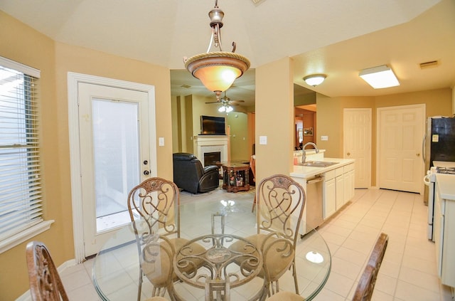 dining area featuring ceiling fan, sink, and light tile patterned floors