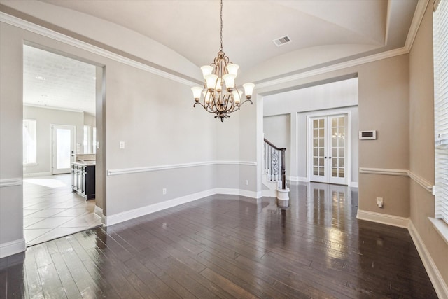 unfurnished room featuring french doors, dark wood-type flooring, lofted ceiling, crown molding, and an inviting chandelier