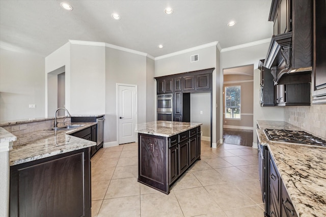 kitchen featuring light tile patterned flooring, dark brown cabinetry, sink, light stone countertops, and decorative backsplash