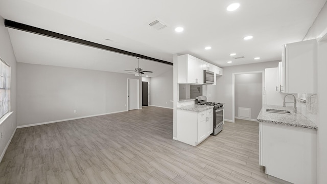 kitchen with sink, stainless steel appliances, white cabinets, and light stone countertops