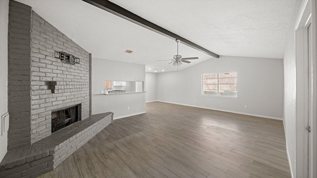 unfurnished living room with dark wood-type flooring, a fireplace, lofted ceiling with beams, and ceiling fan