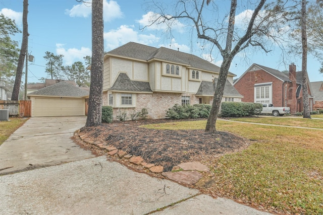 view of front of property with cooling unit, a garage, and a front yard