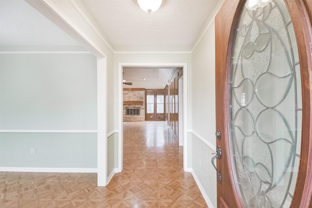 hall featuring light parquet flooring, ornamental molding, and a textured ceiling