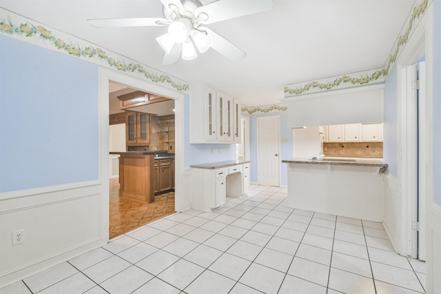 kitchen with white cabinetry, light parquet flooring, ceiling fan, and kitchen peninsula