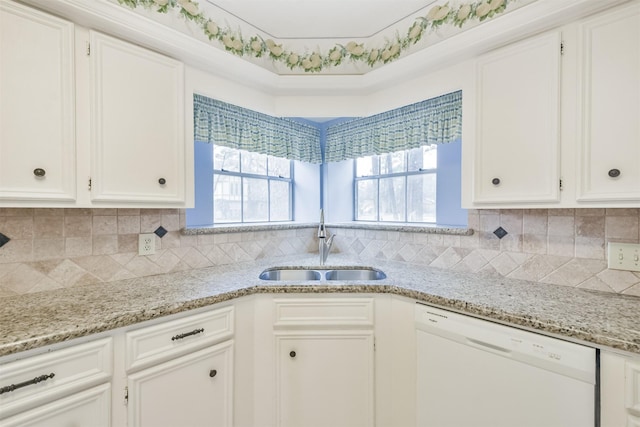 kitchen with white dishwasher, light stone countertops, sink, and white cabinets