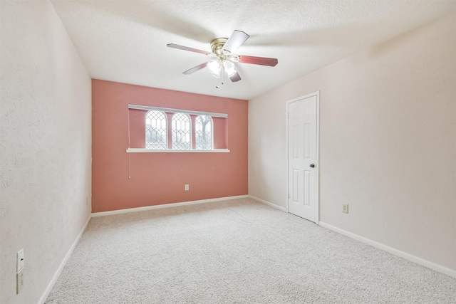 carpeted empty room with ceiling fan and a textured ceiling