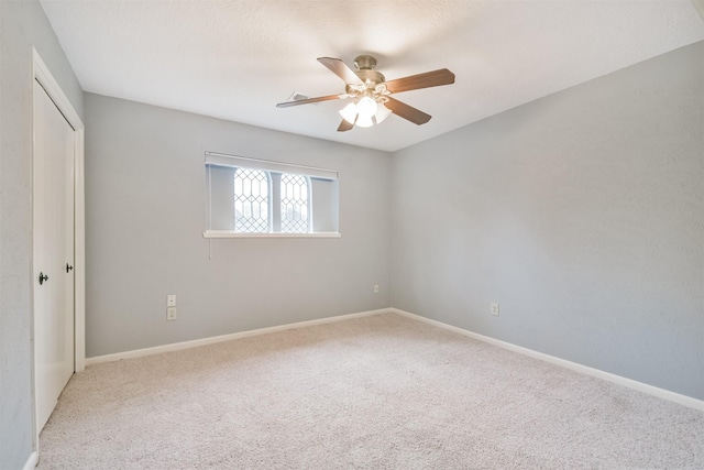 carpeted empty room featuring ceiling fan