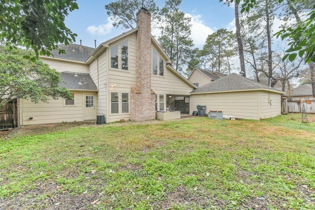 back of property featuring cooling unit and a lawn