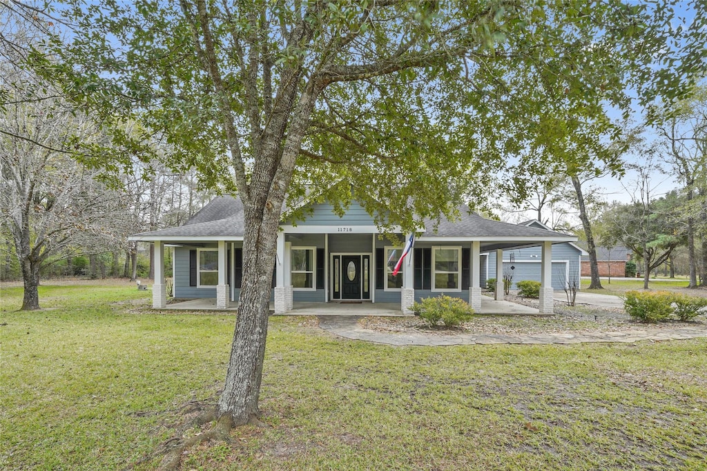 view of front of house with a garage, covered porch, and a front lawn