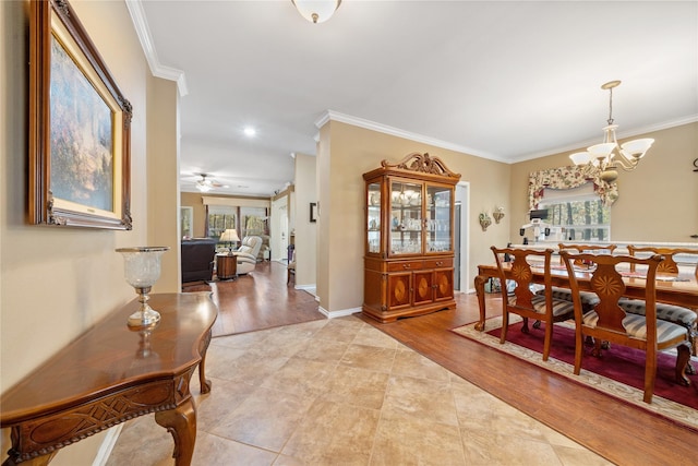 dining room with ornamental molding, ceiling fan with notable chandelier, and light hardwood / wood-style flooring