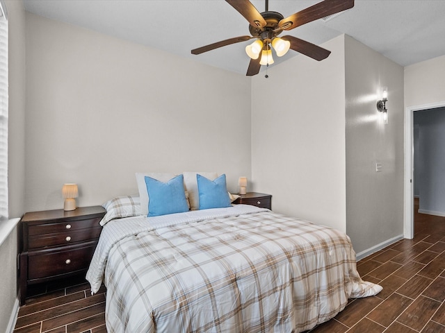 bedroom featuring baseboards, a ceiling fan, and wood finish floors