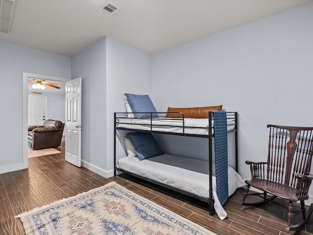 bedroom featuring wood tiled floor, visible vents, and baseboards