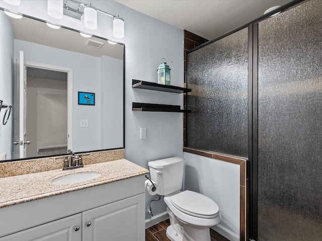 bathroom with toilet, wood finish floors, visible vents, vanity, and a shower stall