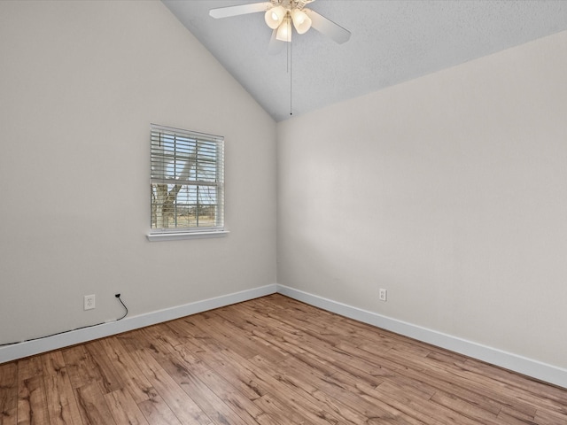 spare room featuring lofted ceiling, wood finished floors, a ceiling fan, and baseboards