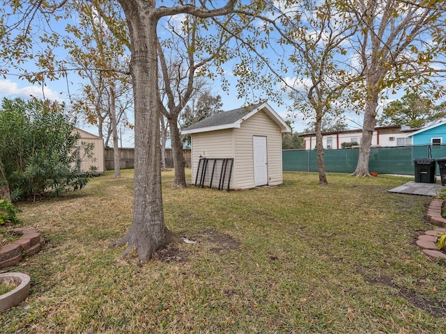 view of yard featuring a storage shed, a fenced backyard, and an outdoor structure