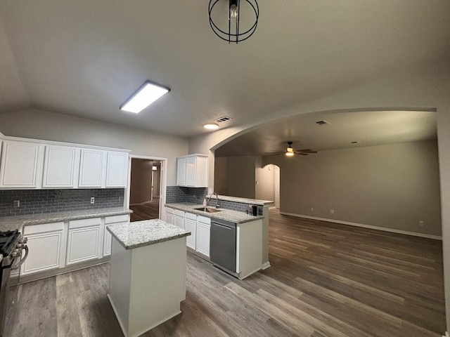 kitchen featuring sink, white cabinetry, backsplash, stainless steel appliances, and a center island