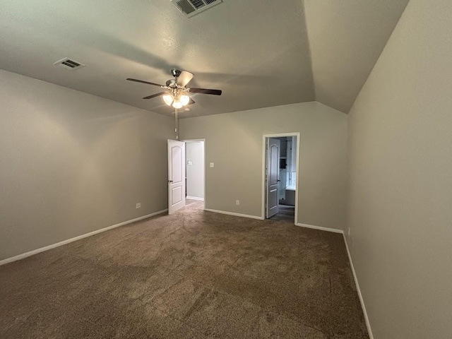 unfurnished bedroom featuring vaulted ceiling, dark carpet, ceiling fan, and ensuite bath