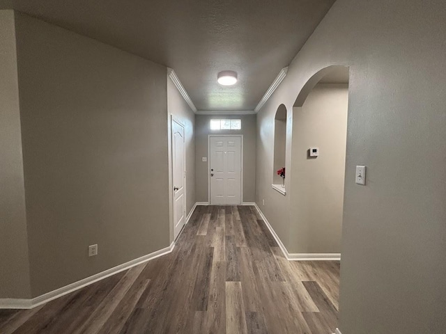 doorway with ornamental molding and hardwood / wood-style floors